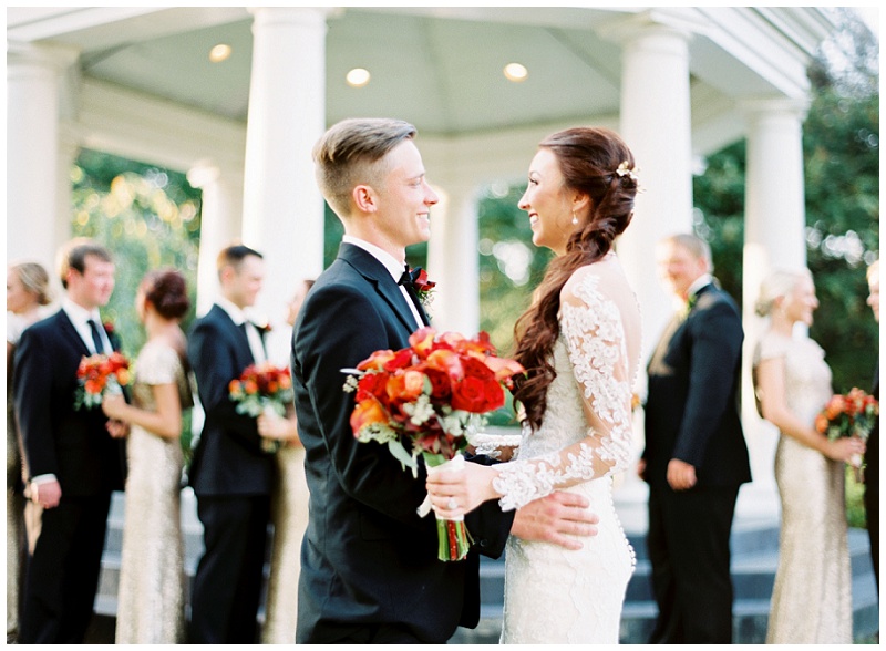 Bride and groom looking at each other with the bridal party in the background