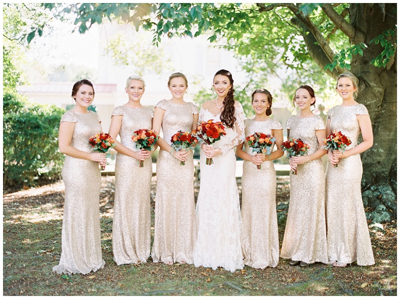 bride and bridesmaids wearing sparkling dress behind allandale mansion