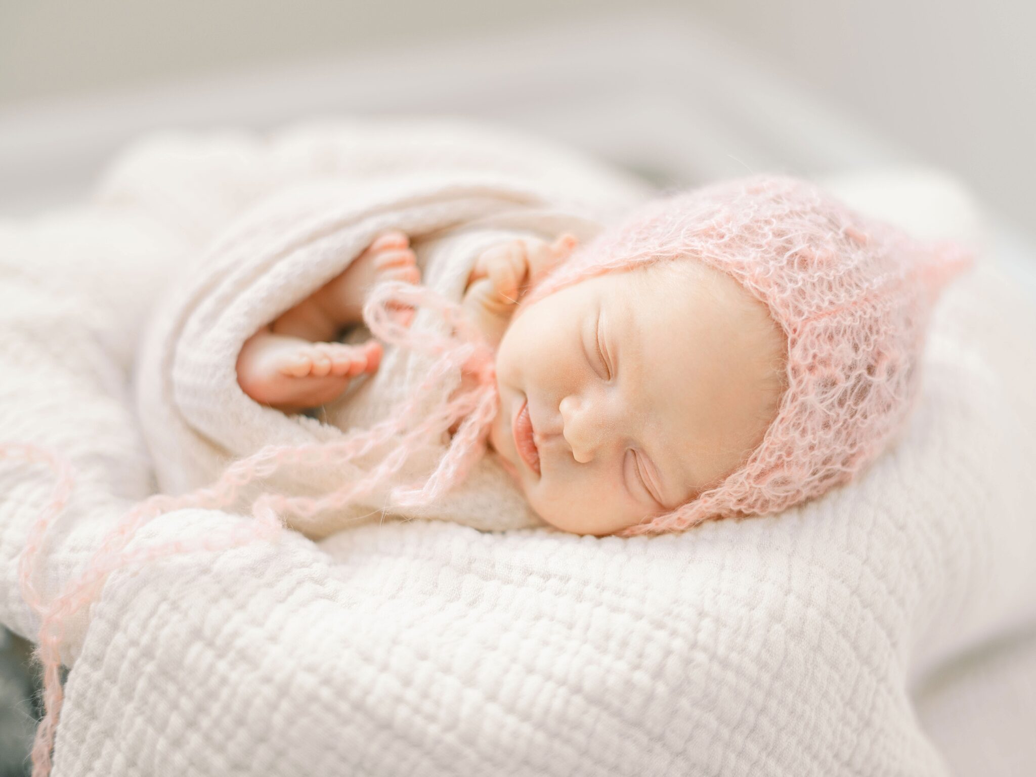 Newborn curled up naturally on soft textured blanket Newborn curled up naturally on soft textured blanket