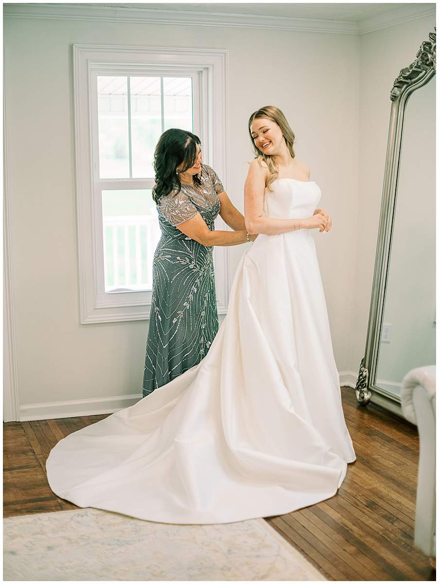 bride getting into dress at Lake House wedding venue Boone Lake