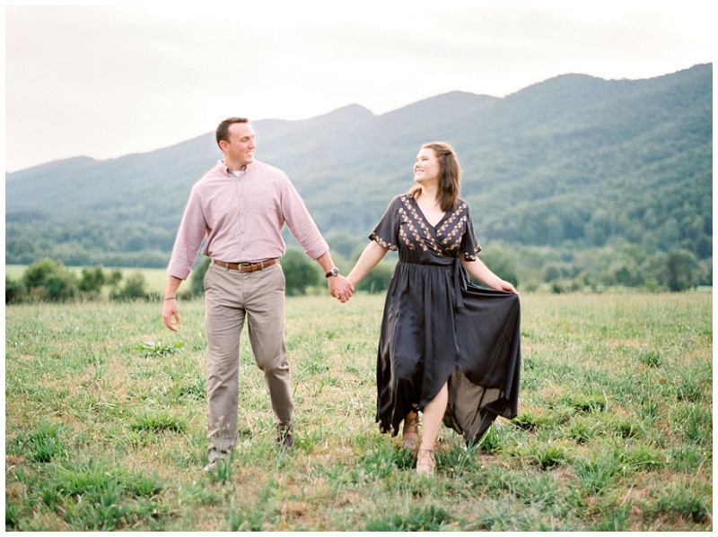 couple walking through mountain field Kingsport TN engagement