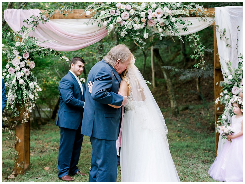 bride hugging dad at wedding ceremony