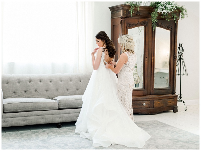 bridesmaids helping bride with dress
