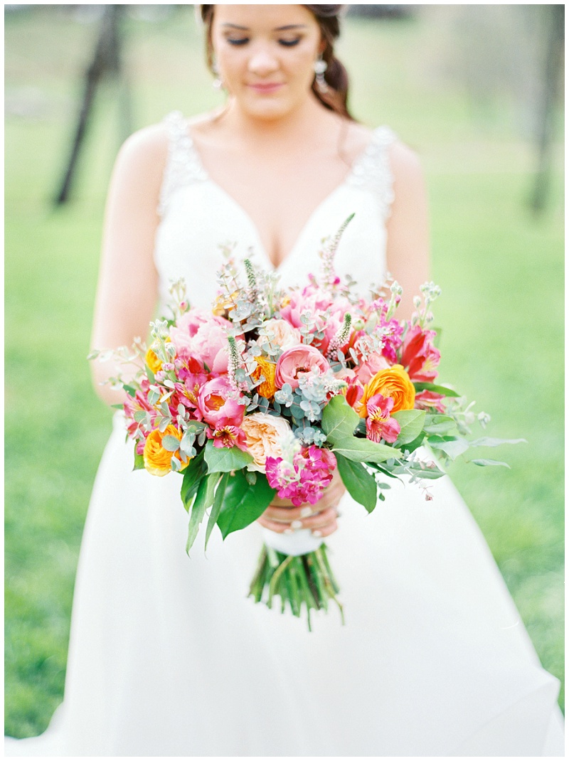bride holding bright pink floral bouquet 