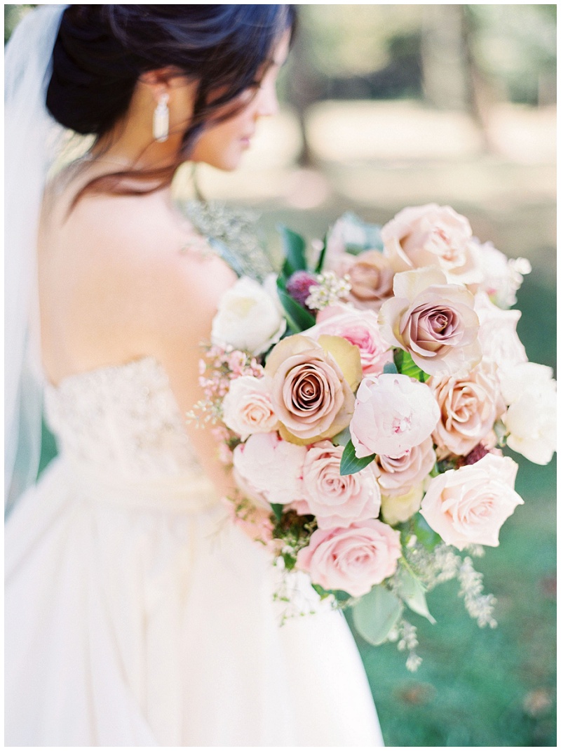 bride holding dress walking field
