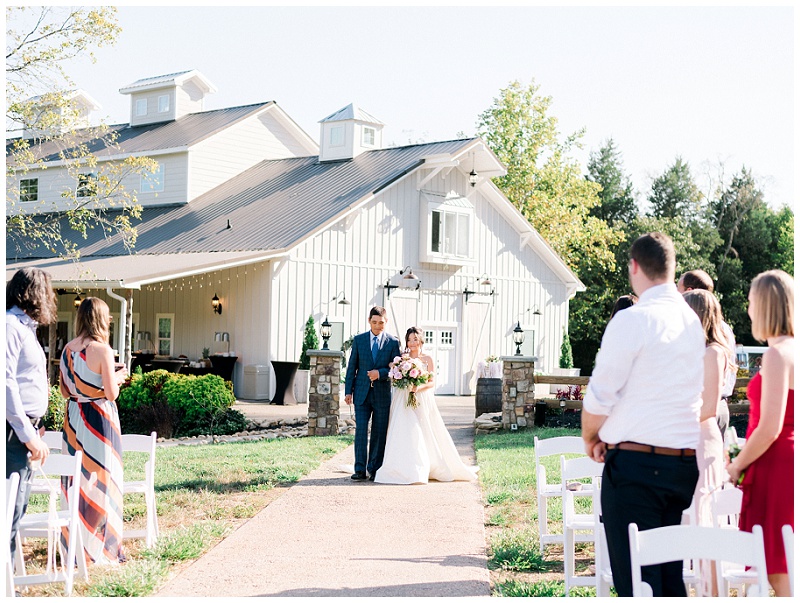 bride walking down aisle barn venue