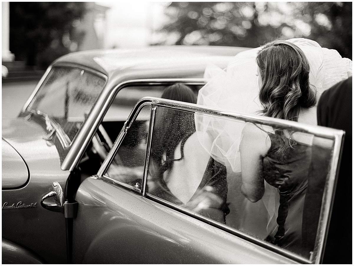 Bride getting into an antique car at The Olde Farm wedding