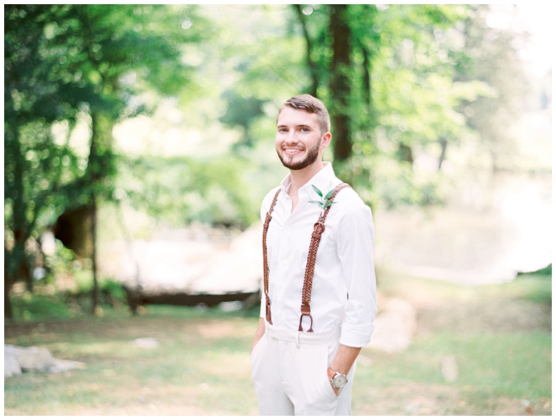 Groom standing in rustic mill The Millstone wedding venue