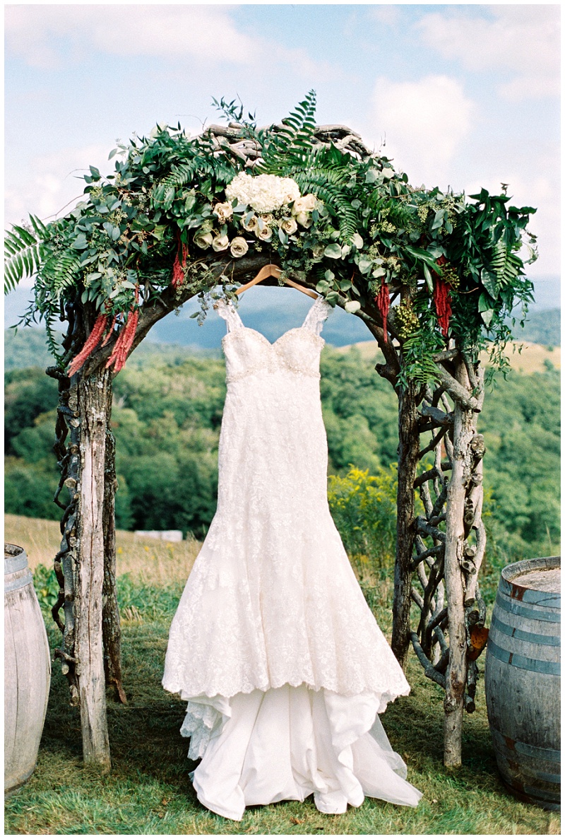 Banner Elk Winery wedding dress detail hanging at ceremony arbor mountain view