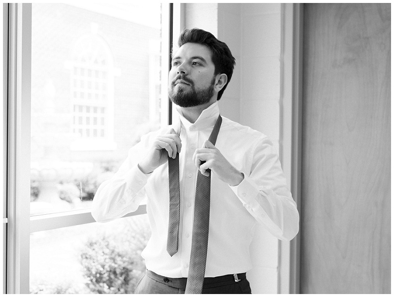 groom putting on tie wedding morning