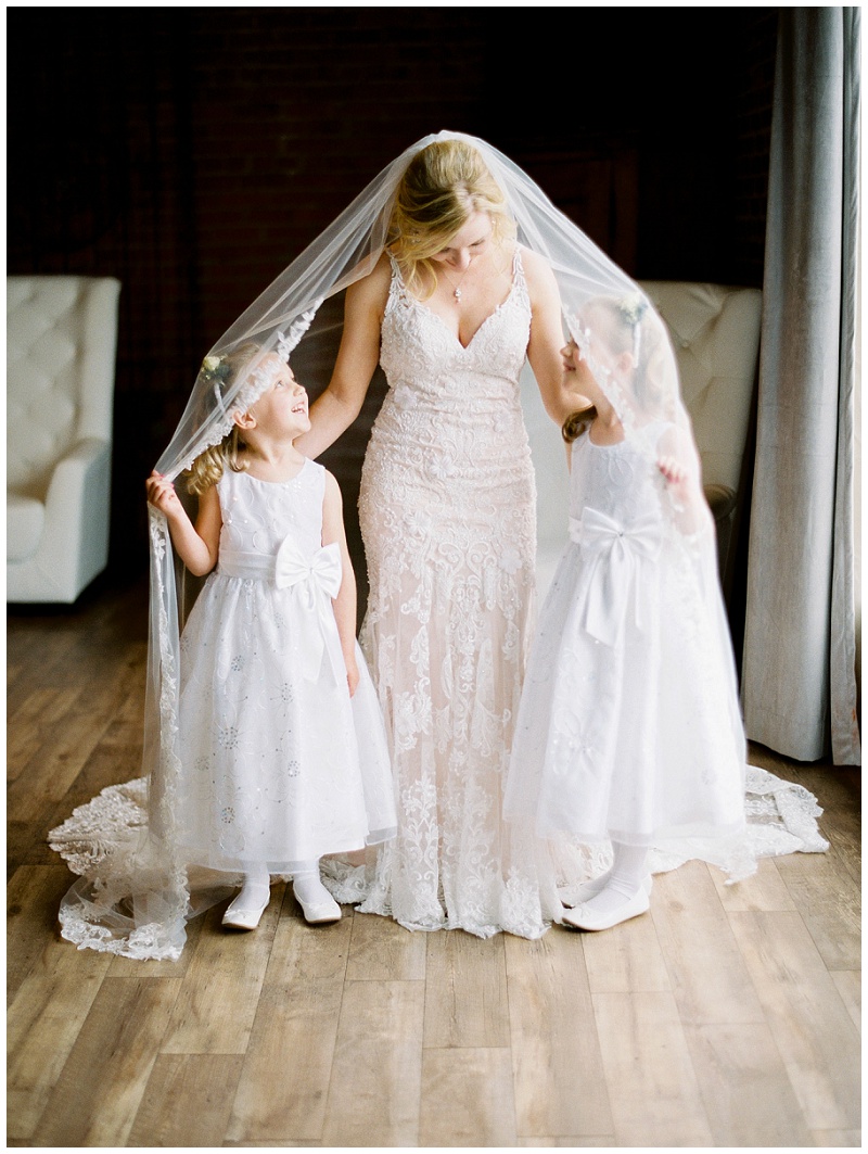 sweet moment with flower girls looking at bride jackson ms wedding