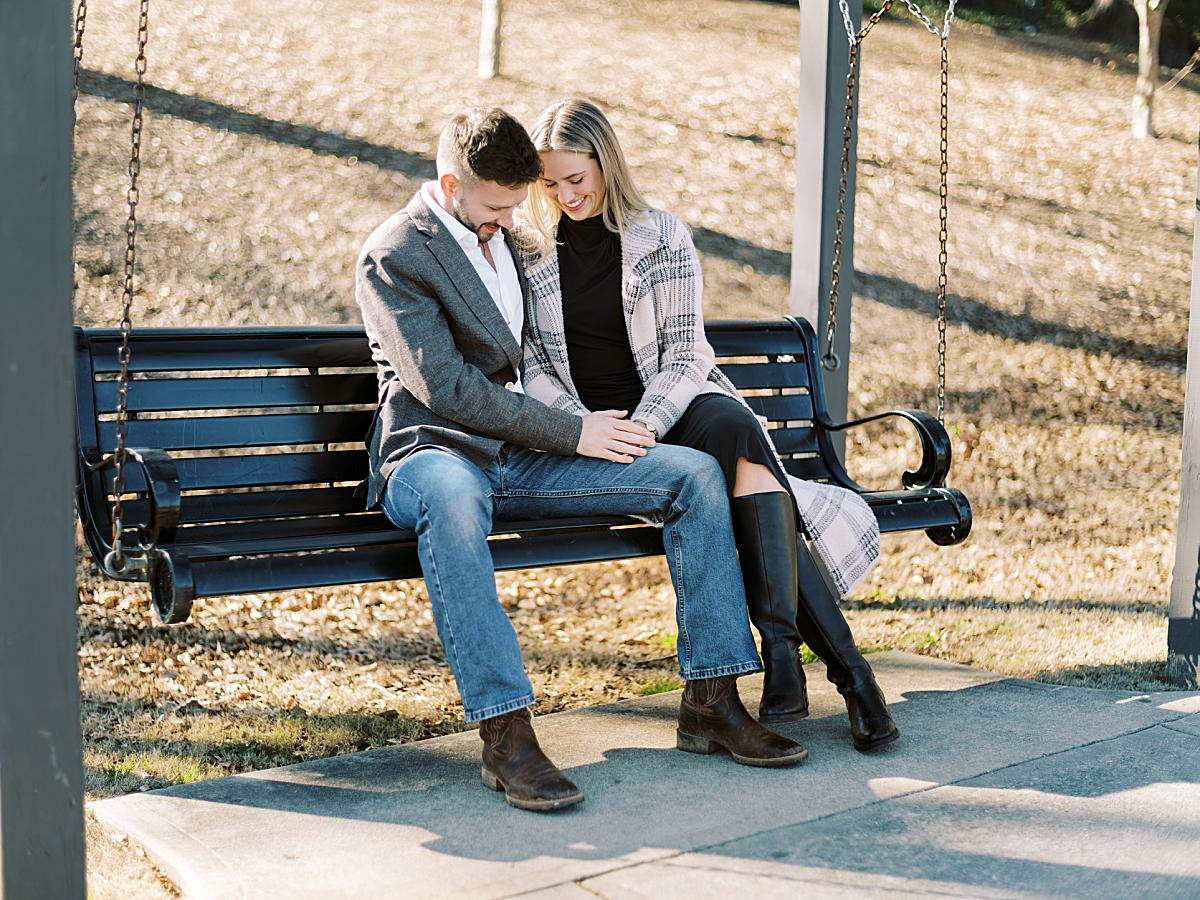 Soft sunlight illuminating the couple while they are sitting together during their engagement photography session. Soft sunlight illuminating the couple while they are sitting together during their engagement photography session.
