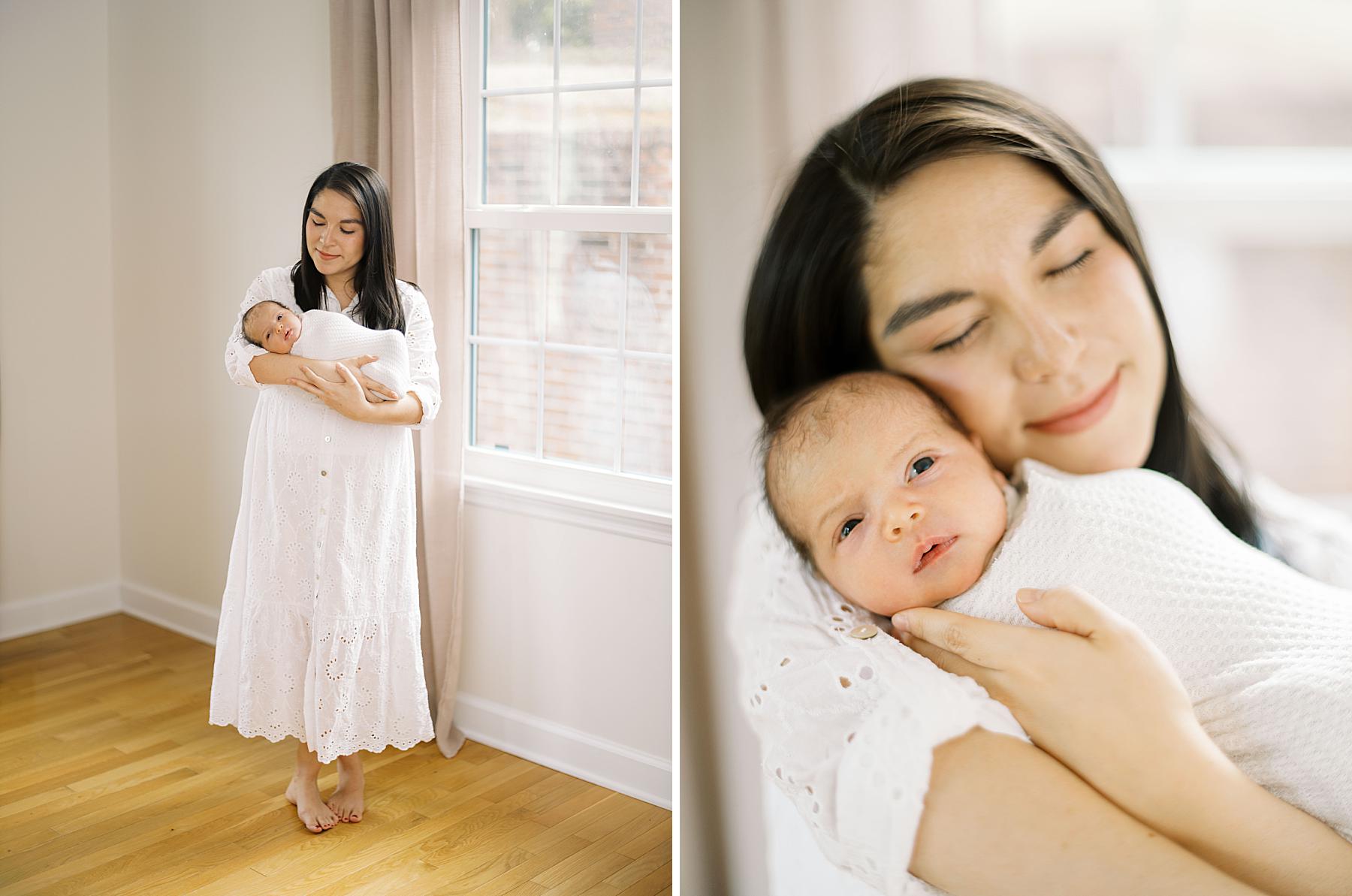 Mother wearing a flowing white client closet dress holding her newborn son