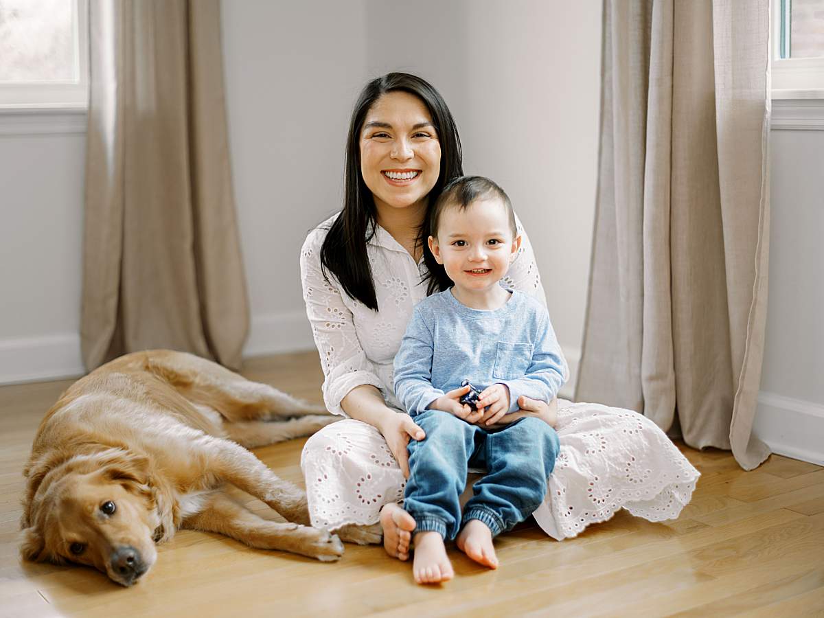 Mother wearing a white dress from the client closet holding her oldest boy