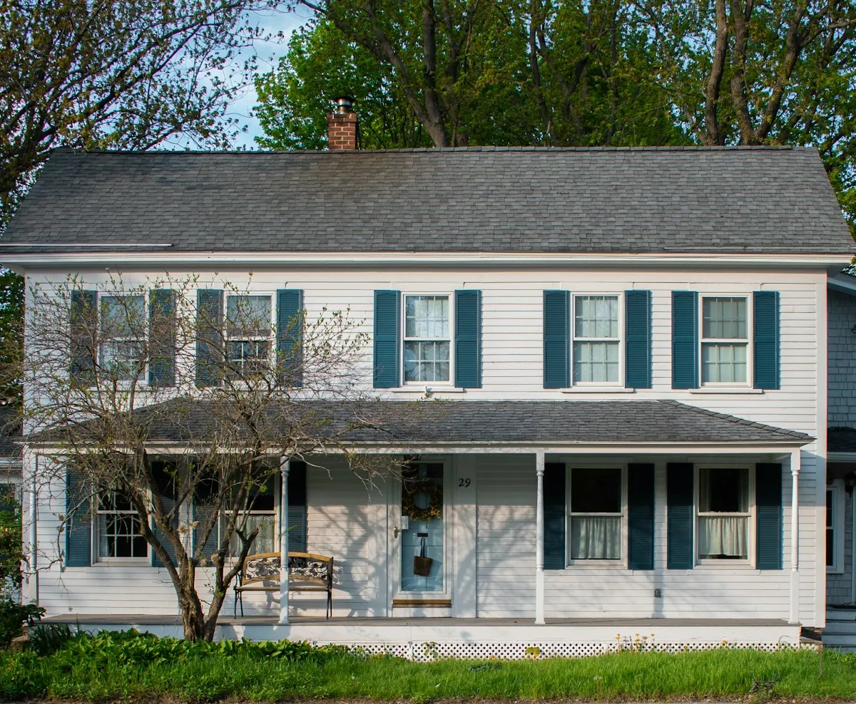 A white house with blue shutters and a front porch