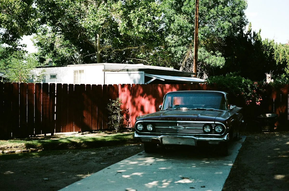 A classic car parked in a sunny driveway
