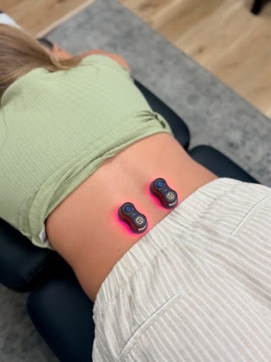 Kineon MOVE+ Pro red light therapy device applied to lower back at Inspire Chiropractic