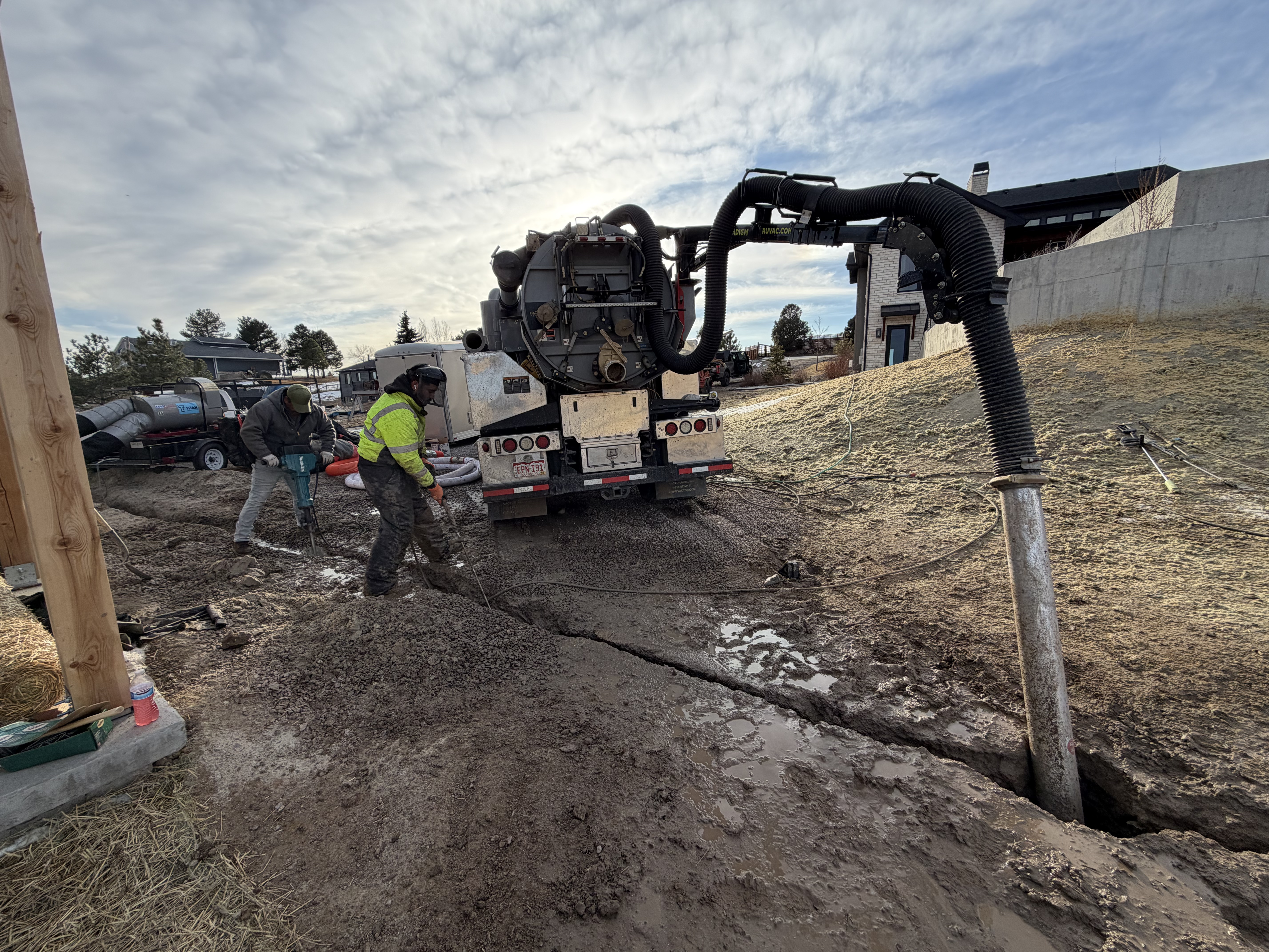 Hydrovac truck performing retention pond cleaning and drainage basin cleanout with vacuum excavation