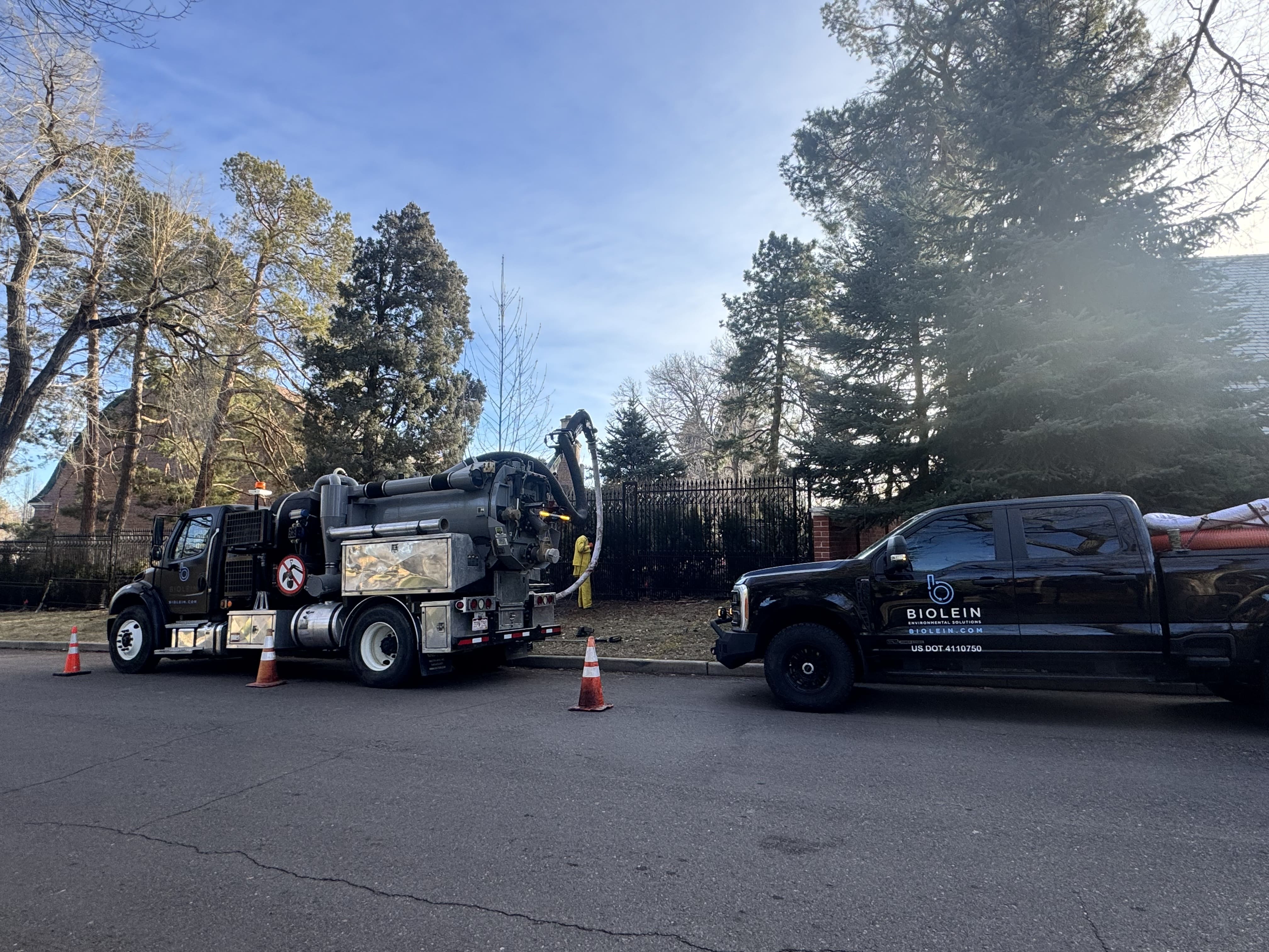 Hydrovac vacuum truck working on residential pond cleaning and drainage maintenance project