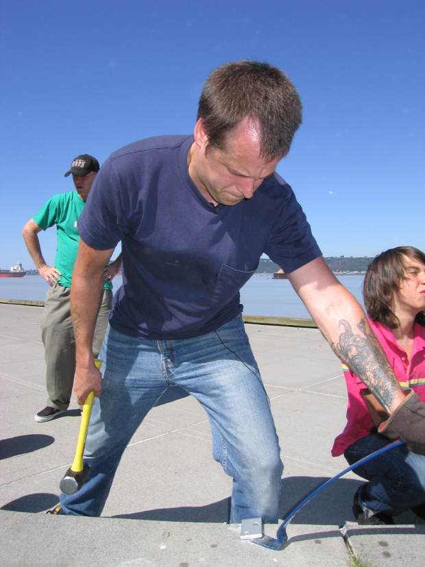 Adult removing skateboard deterrents from public concrete