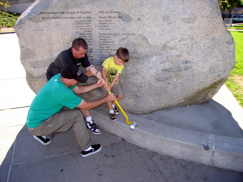 Adults helping a young child remove the final skateboard deterrent