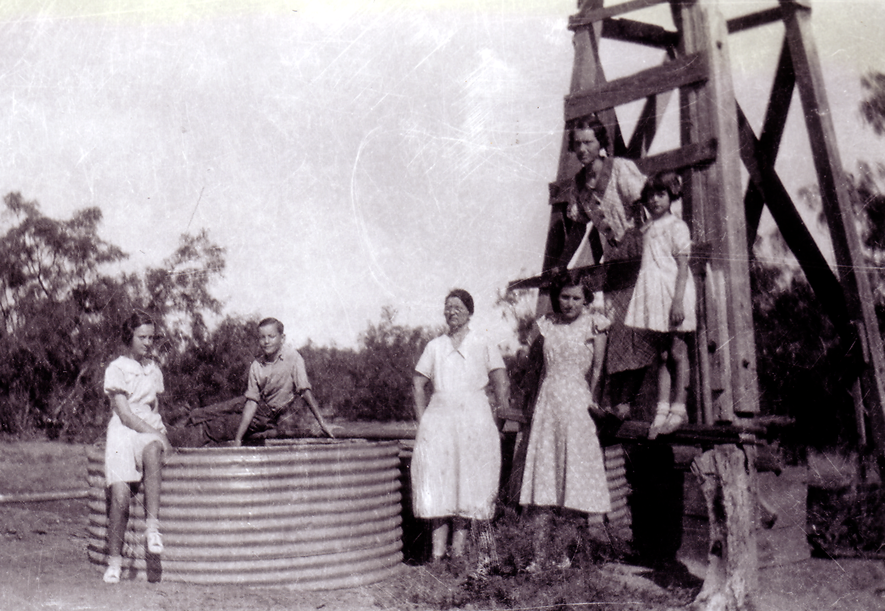 Family beside a windmill on a West Texas farm