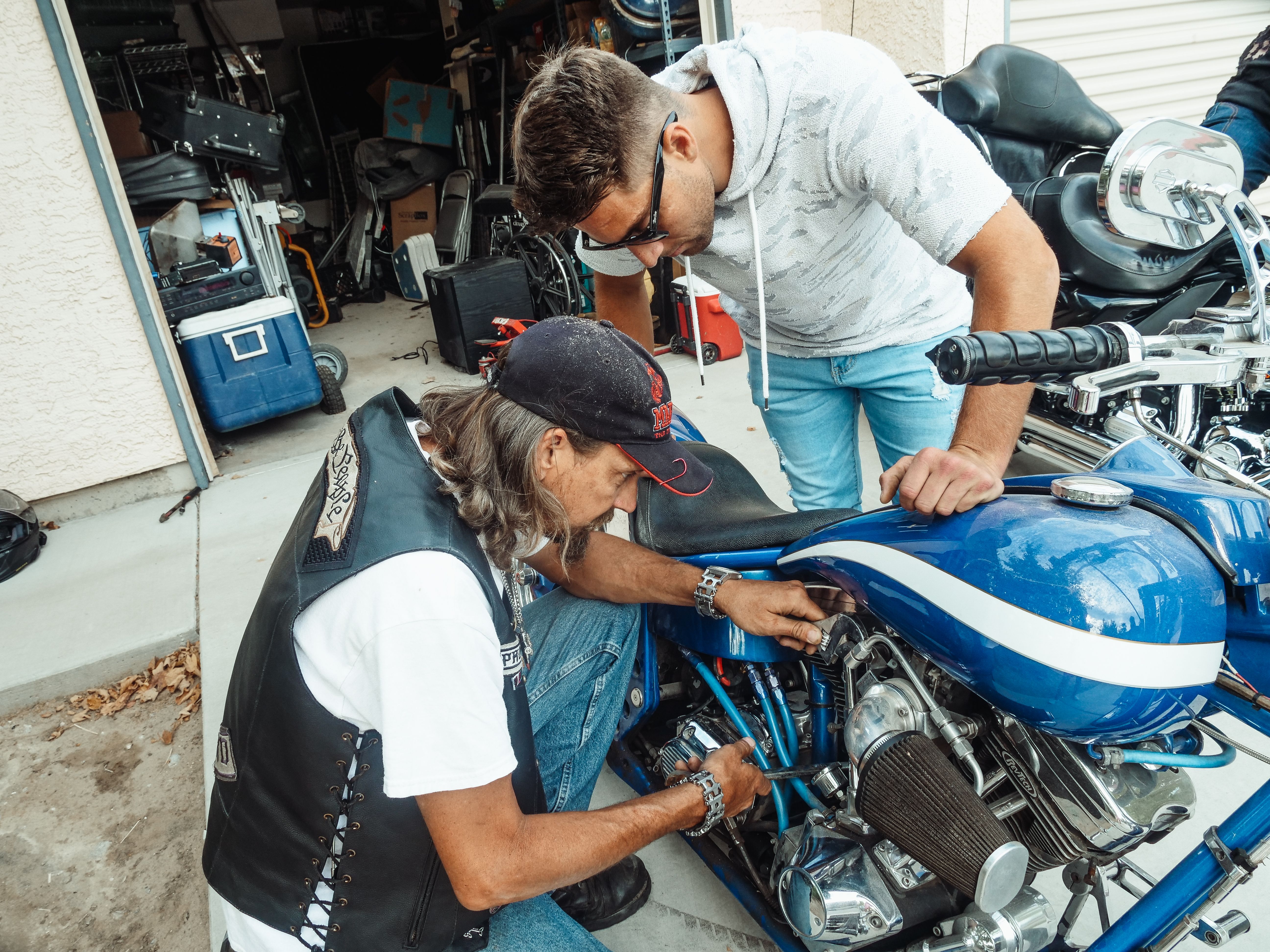 Two people repairing a motorcycle together