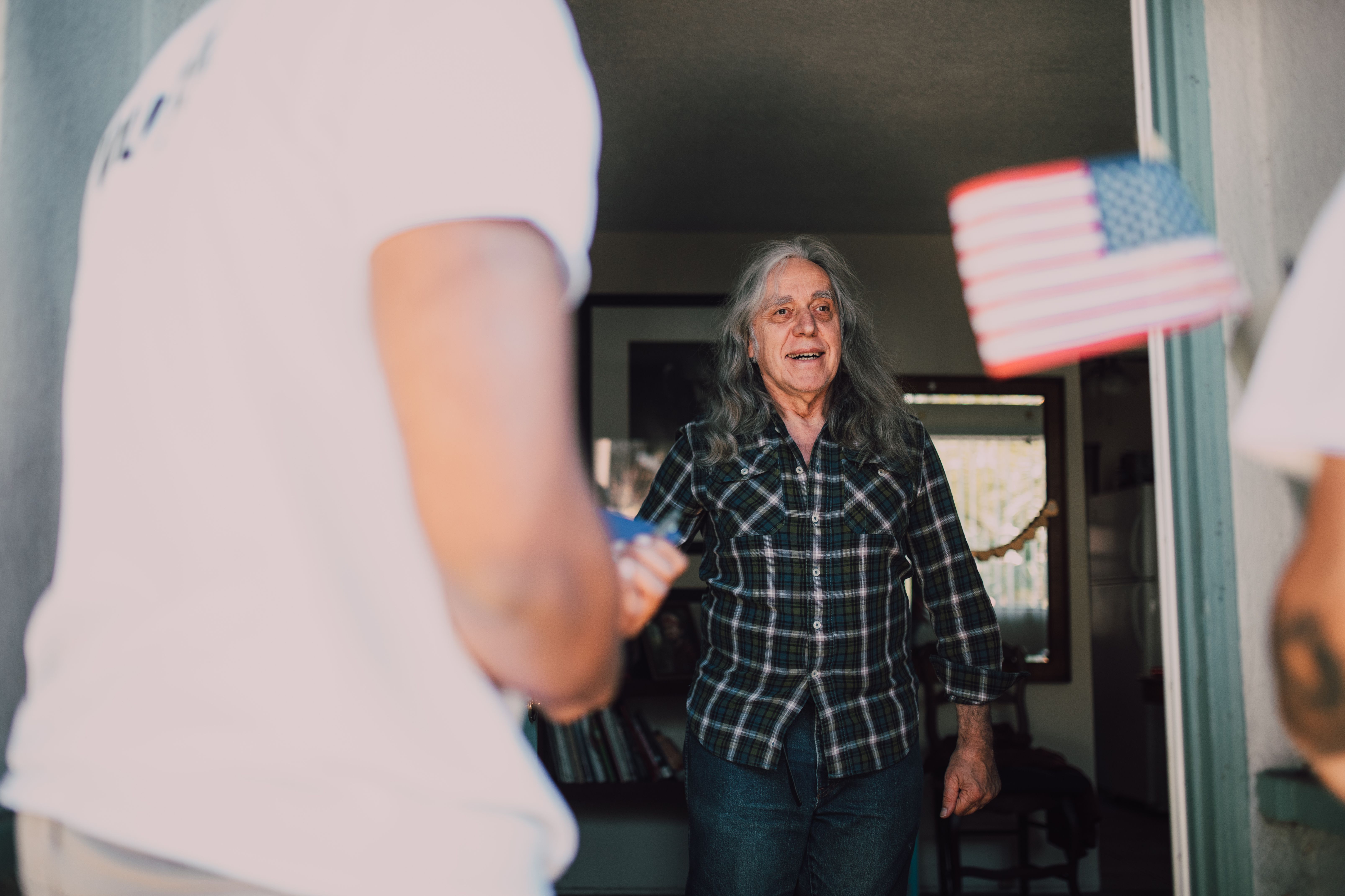 Neighbors or volunteers visiting an older adult at home