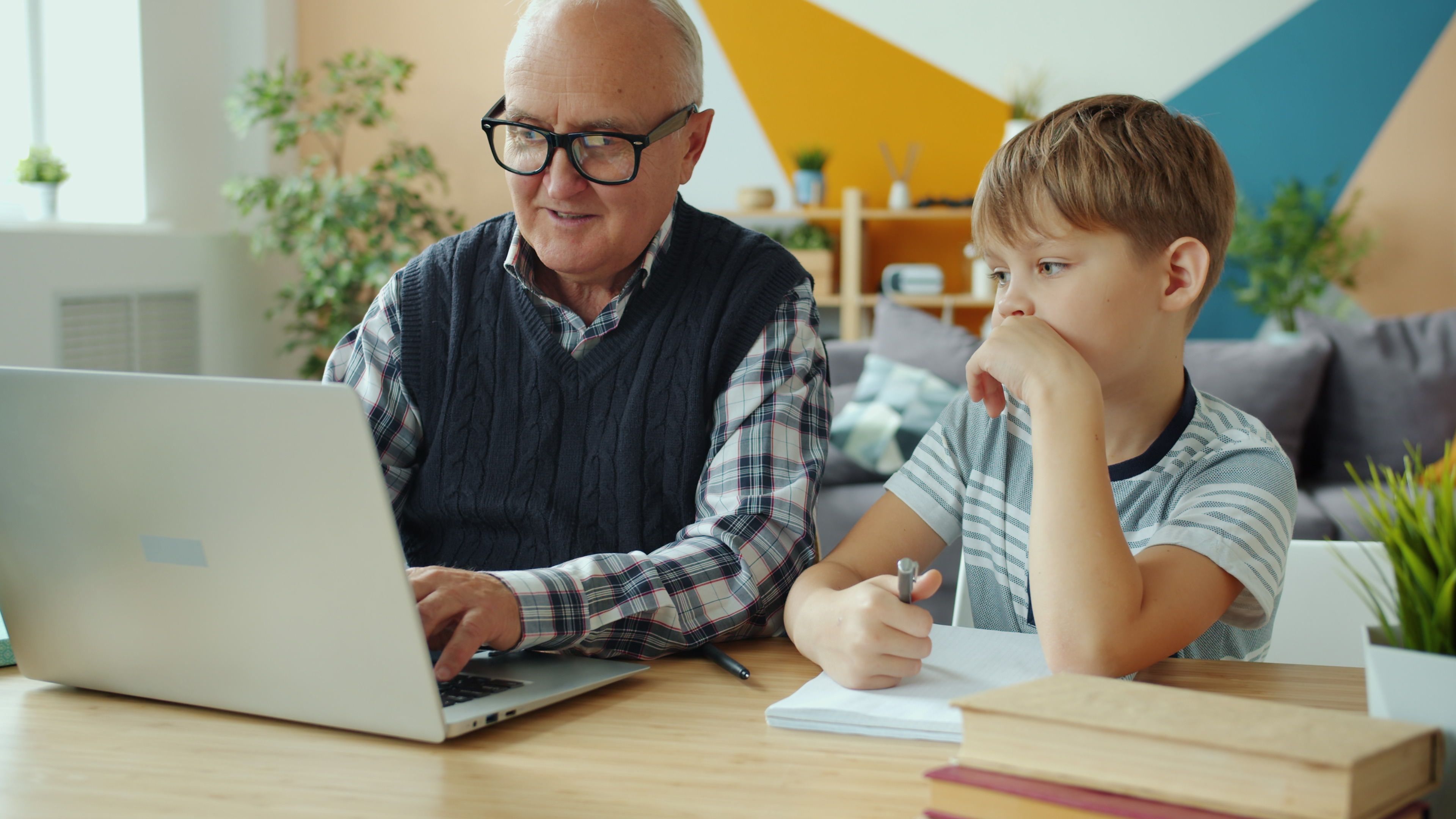 Older man and child learning together at a laptop