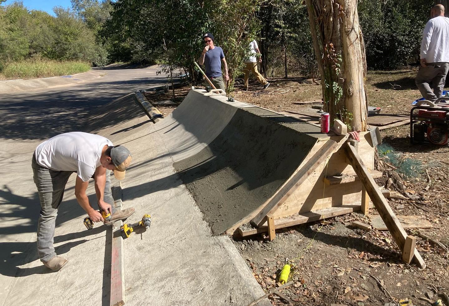 Concrete transition under construction with forms, tools and builders