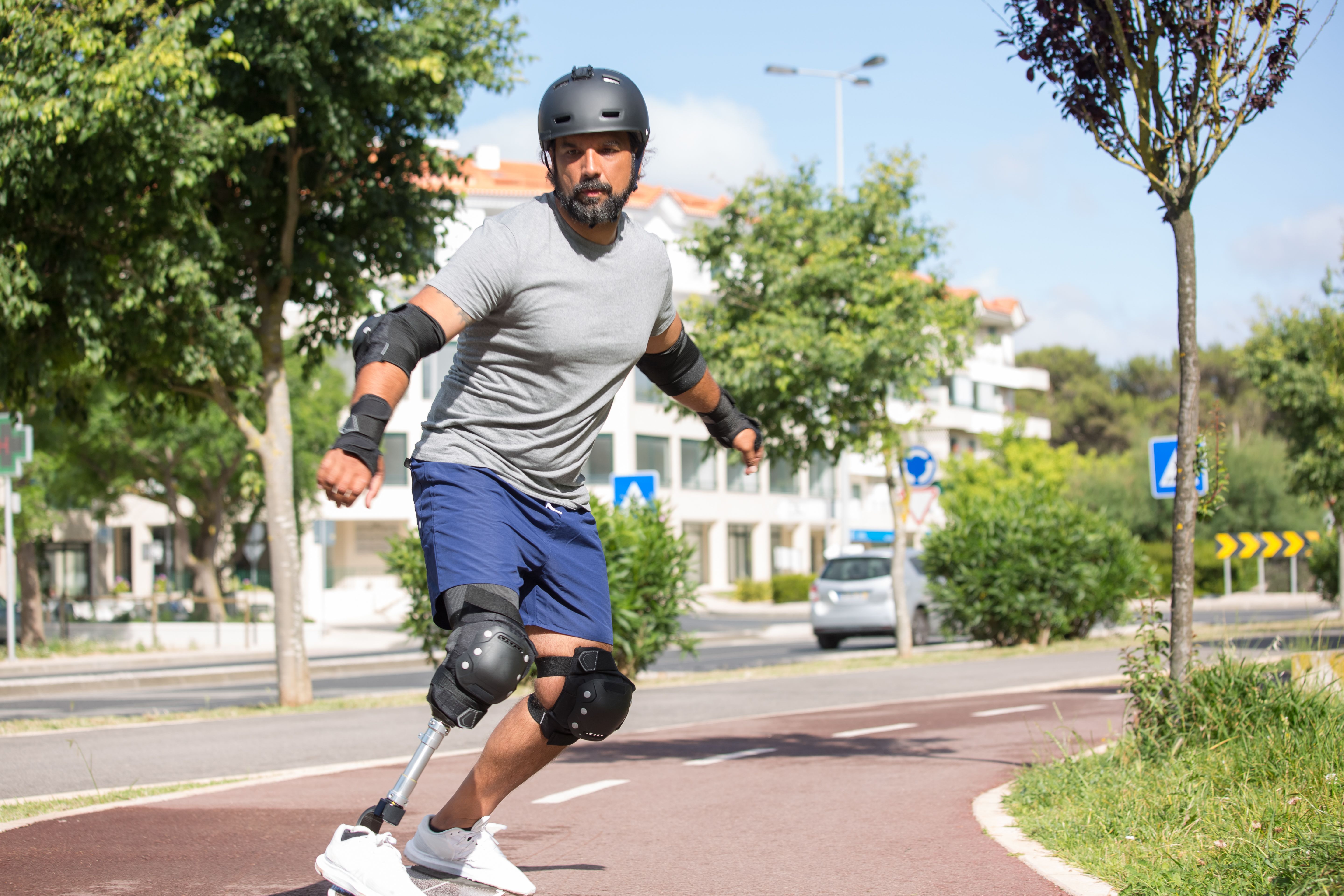 An athlete with a prosthetic leg rollerblading through a public street