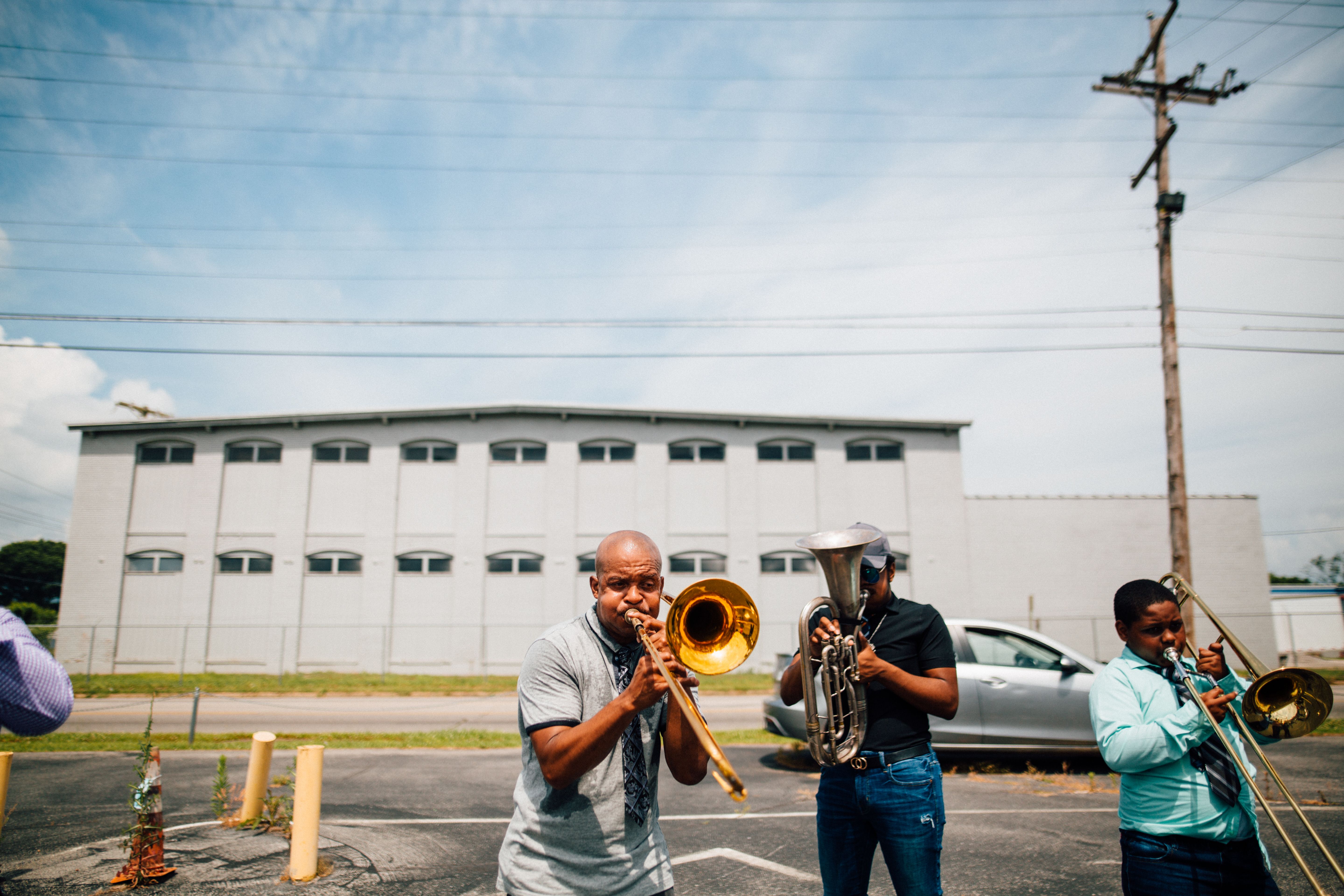 Musicians playing brass instruments together outdoors in a public space