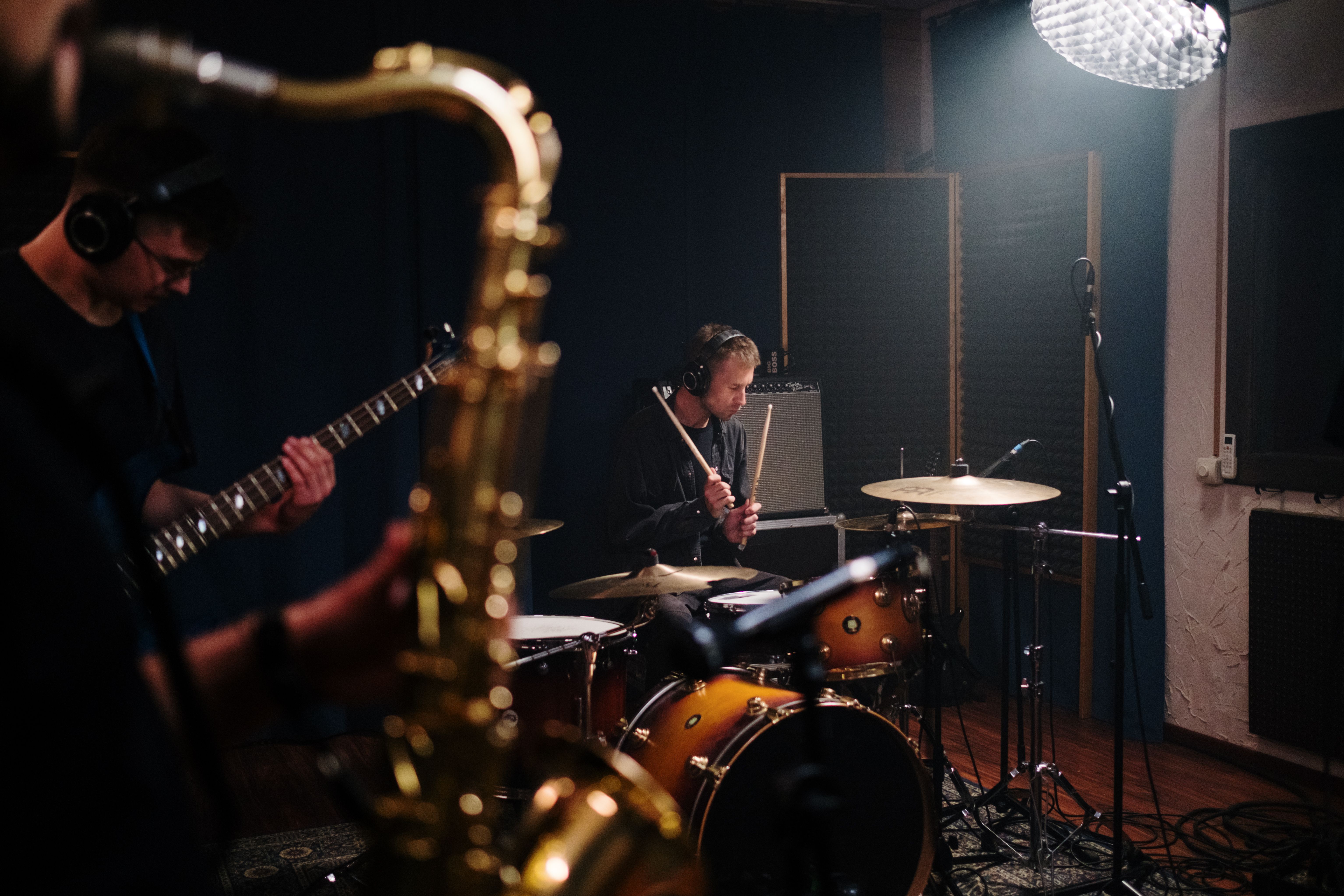 Musicians rehearsing together with saxophone, guitar and drums