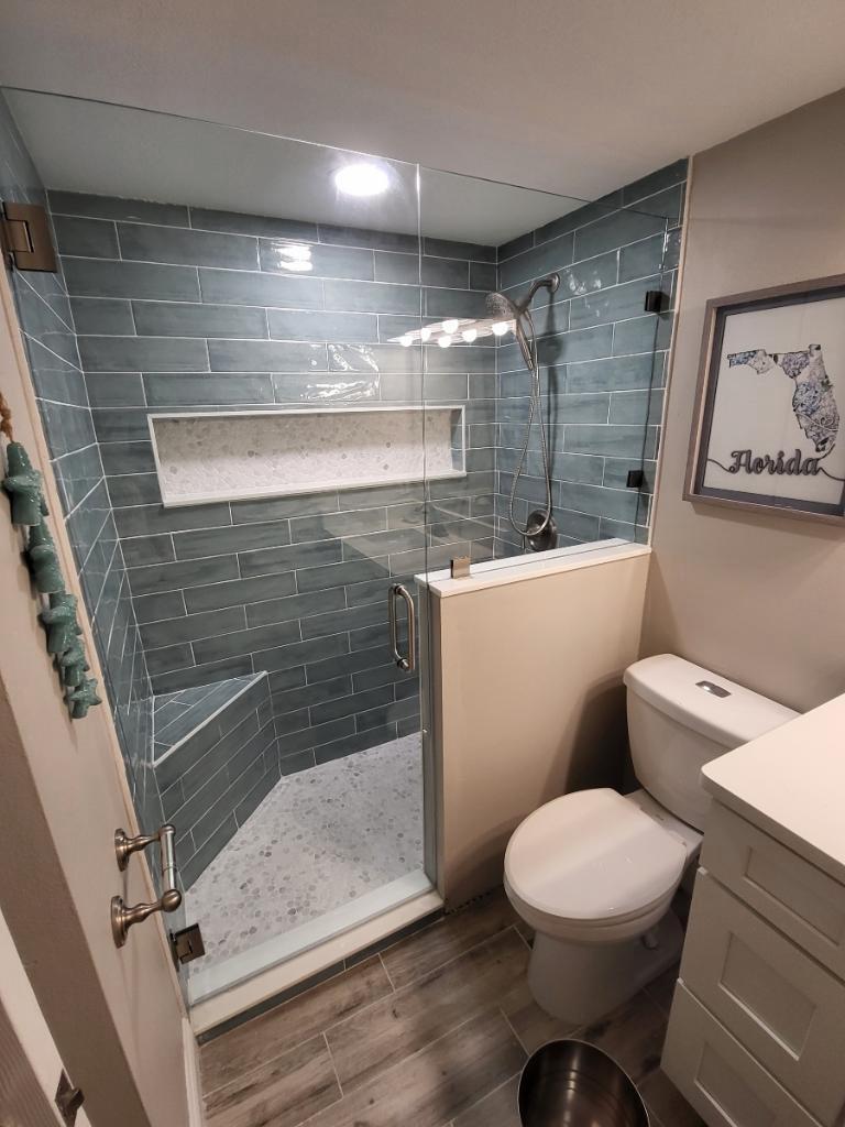 Coastal bathroom remodel with teal tile shower