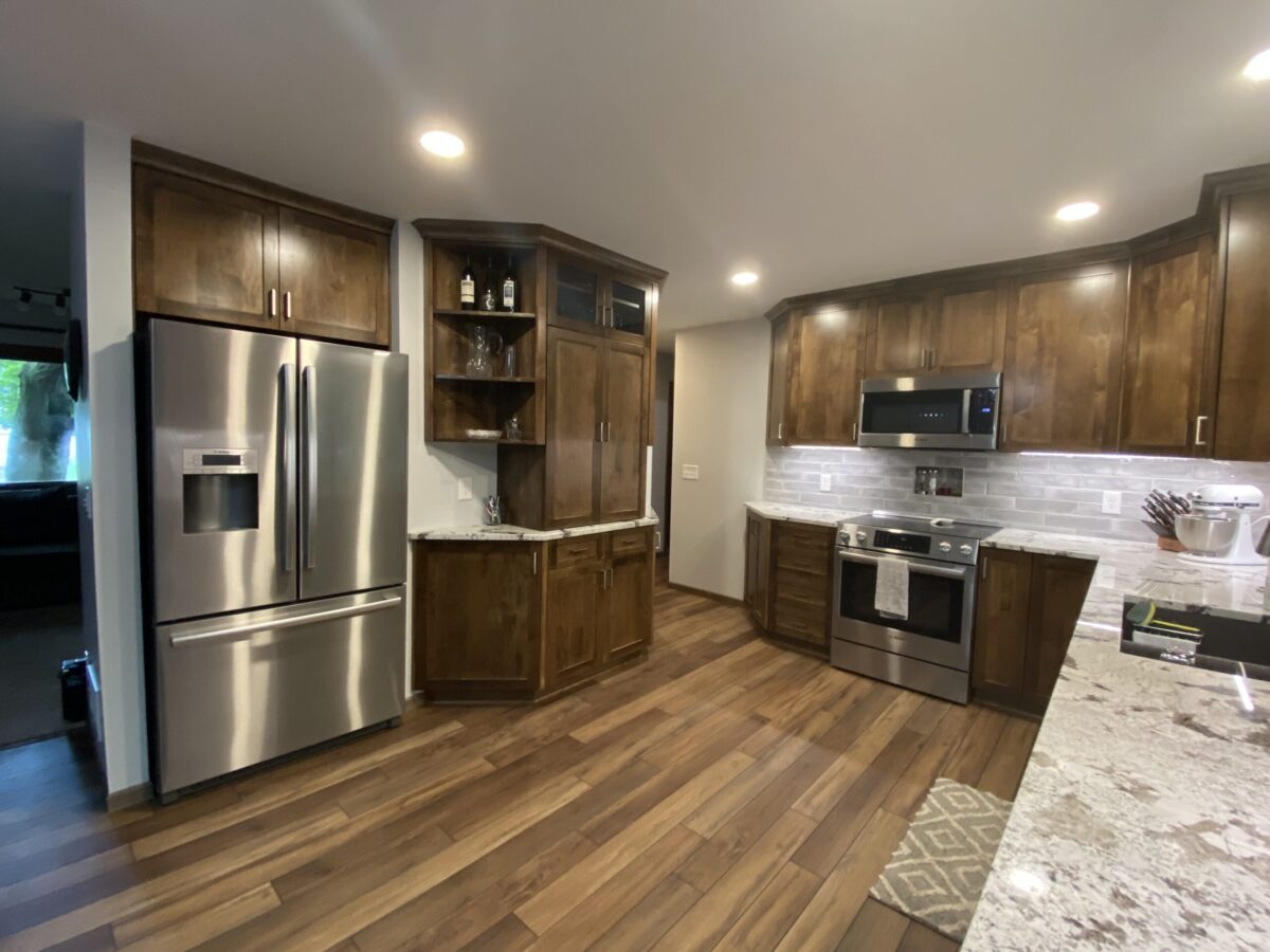 Stained wood-grain cabinets with a corner glass display hutch and granite counters