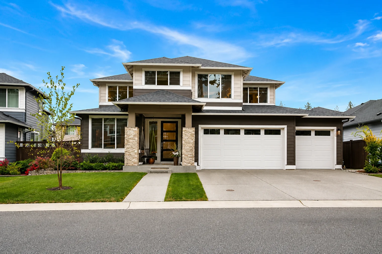 A modern two-story suburban home with dark brown siding, white trim, stone pillars, and a three-car garage.