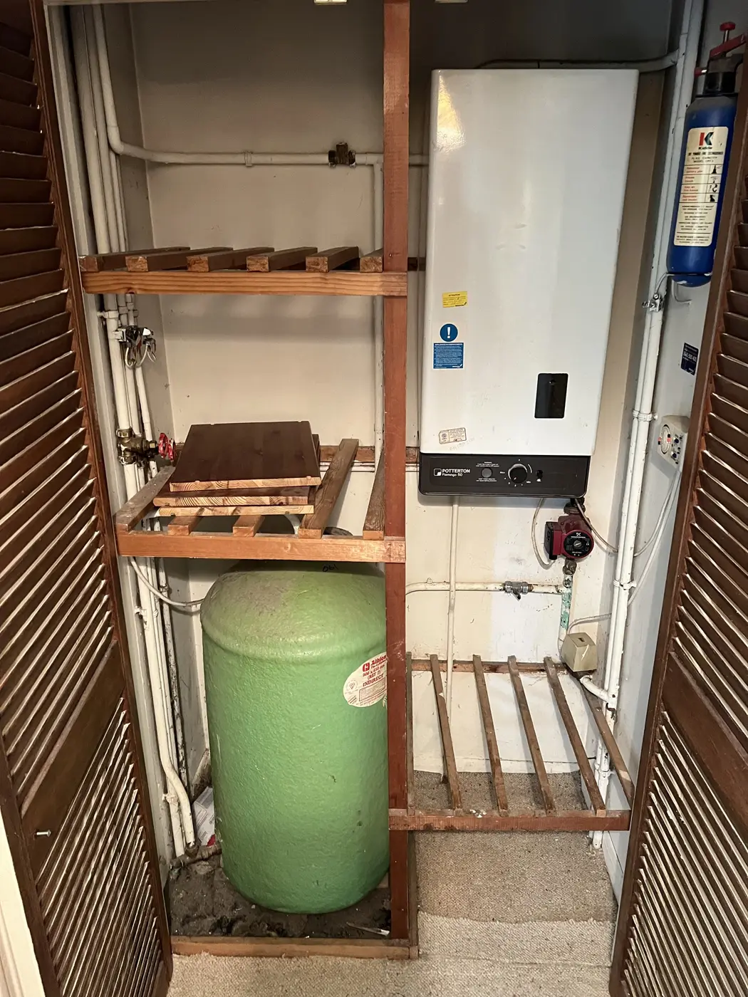 Old hot water cylinder and pipework in an Oxford home before replacement