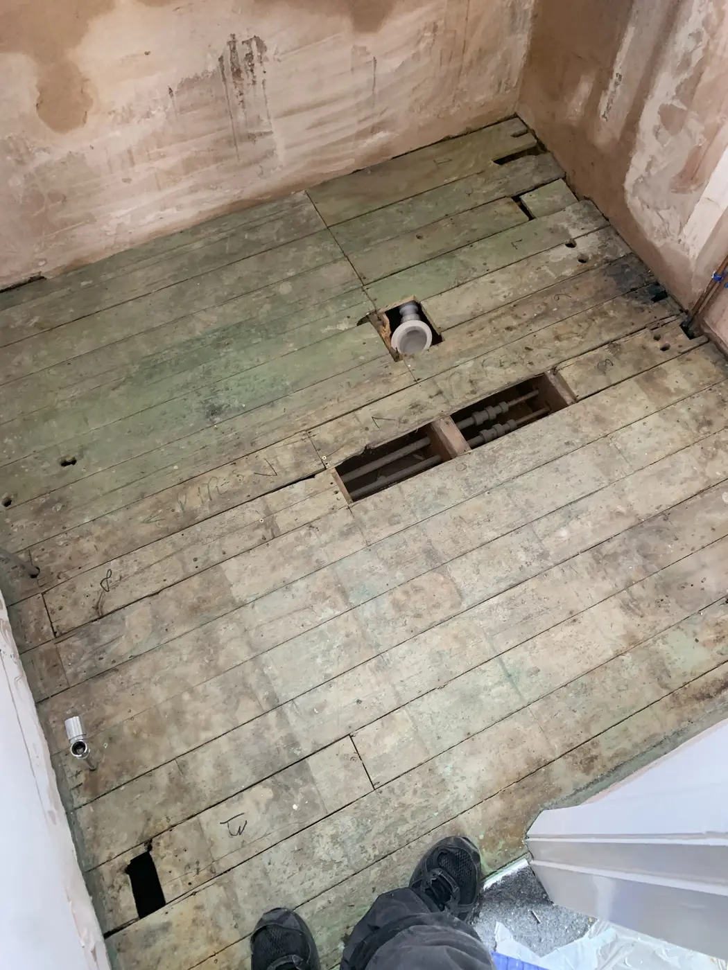 Old floorboards lifted in an Oxford bathroom with new waste in place
