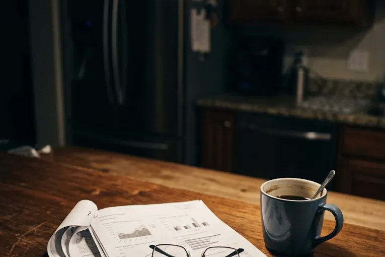 A Retirement Tax Diagnostic report on a kitchen counter beside a coffee mug and reading glasses.