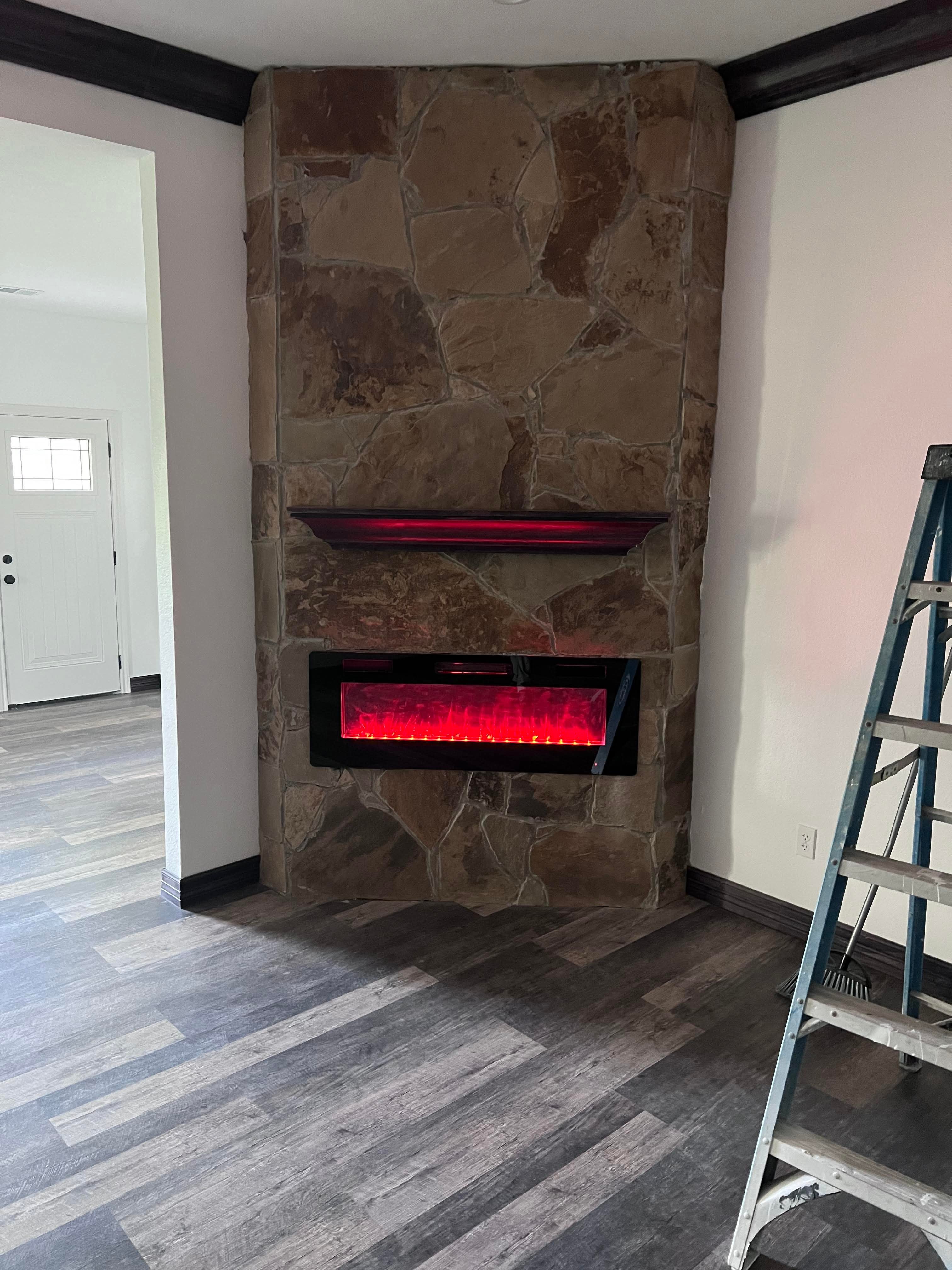 Stone fireplace feature with painted trim and wood floors