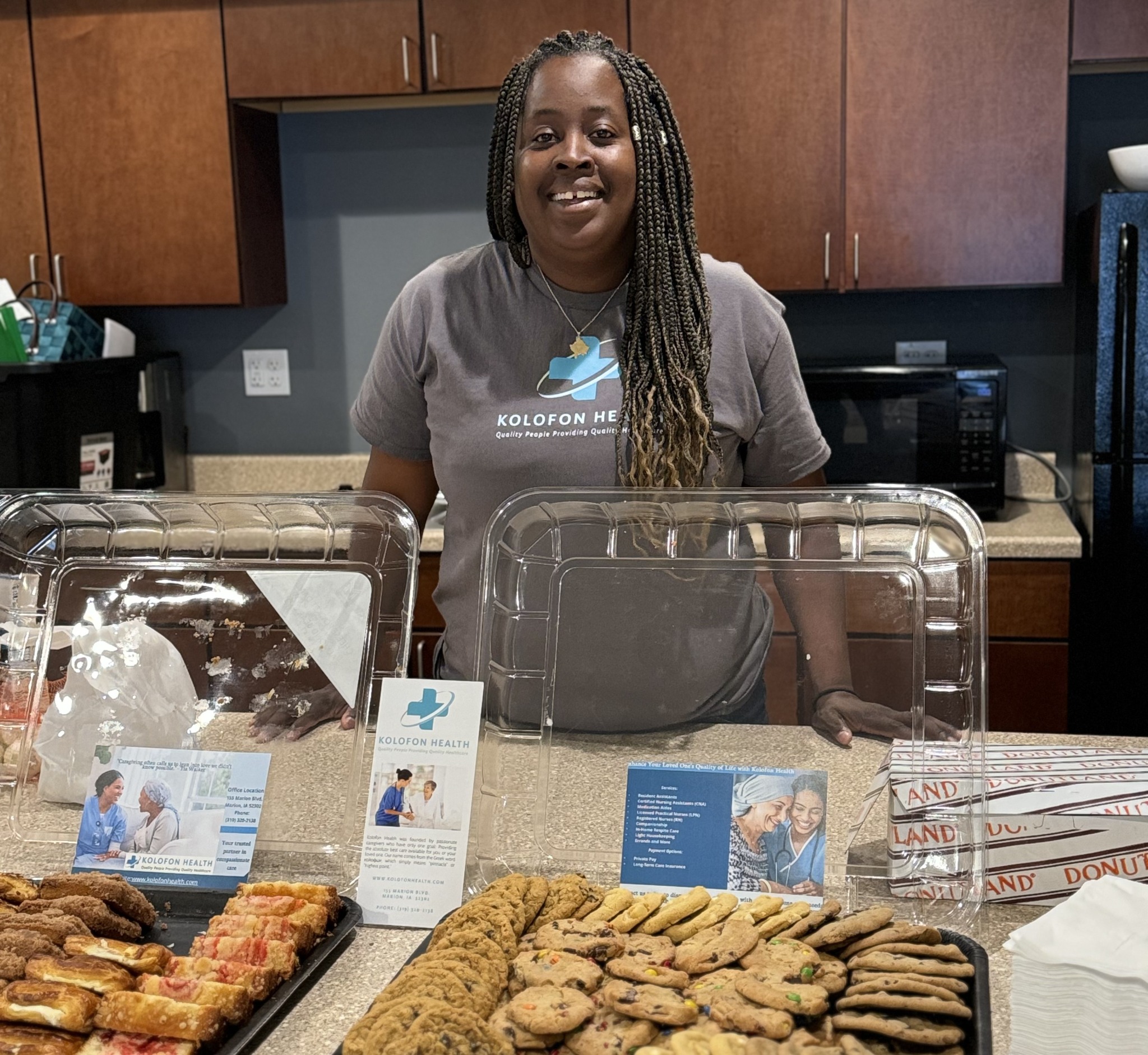Natasha Ajeti at a Coffee and Care event table with cookies and Kolofon Health information