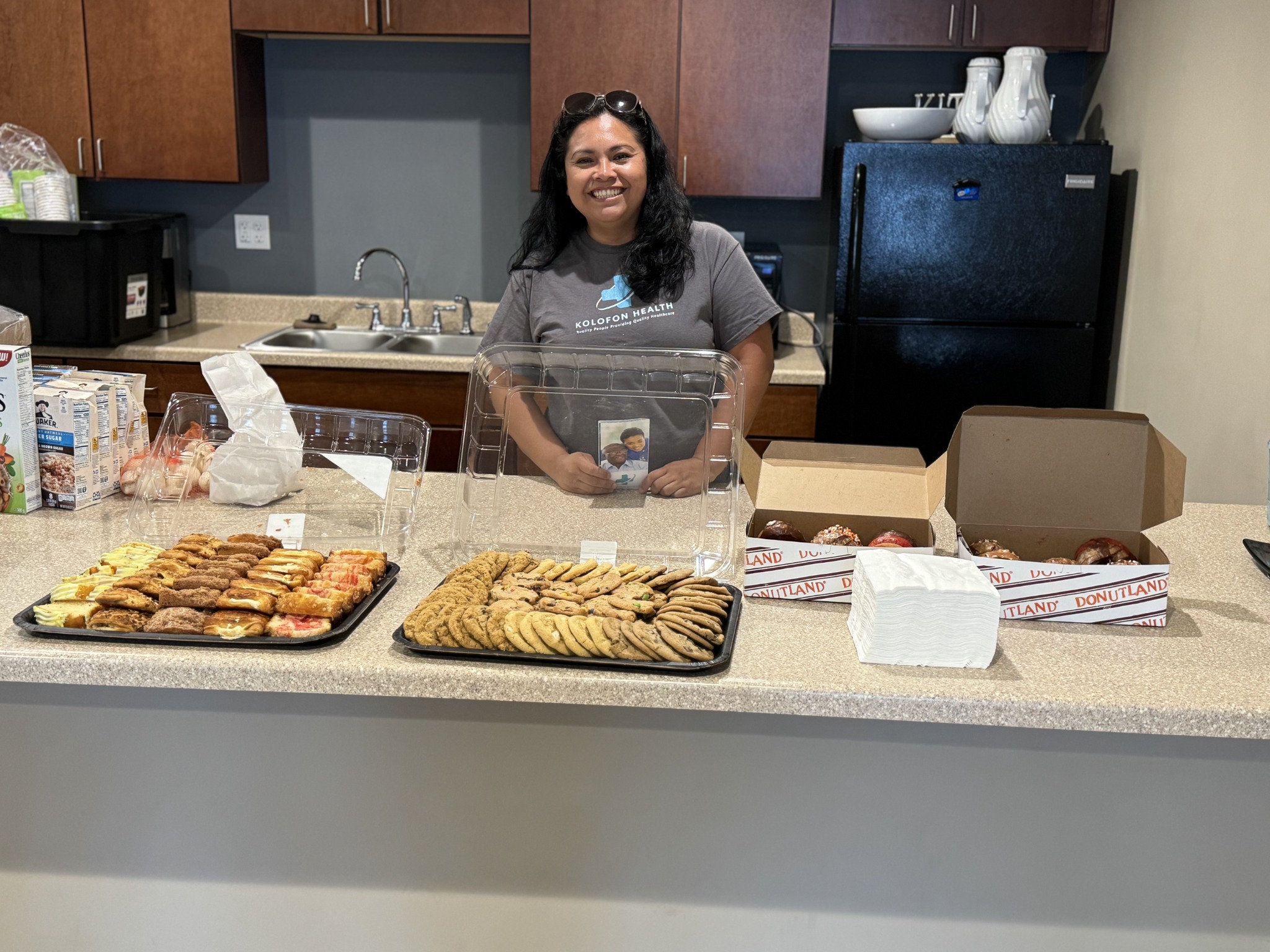Kolofon Health team member behind the cookies and information table at a Coffee and Care gathering