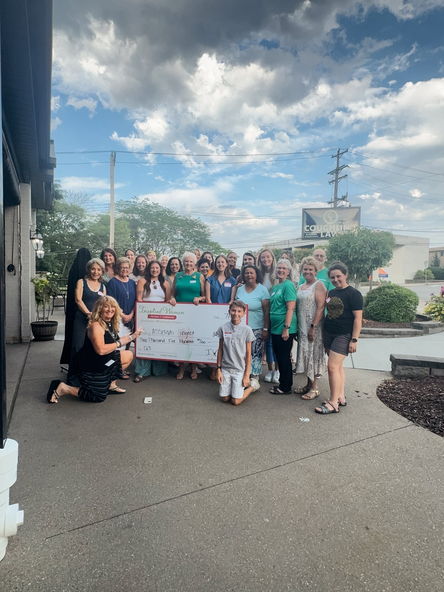 The Asservo Project receiving the ceremonial check from Inspired Women Downtown Pittsburgh members at Le Mont