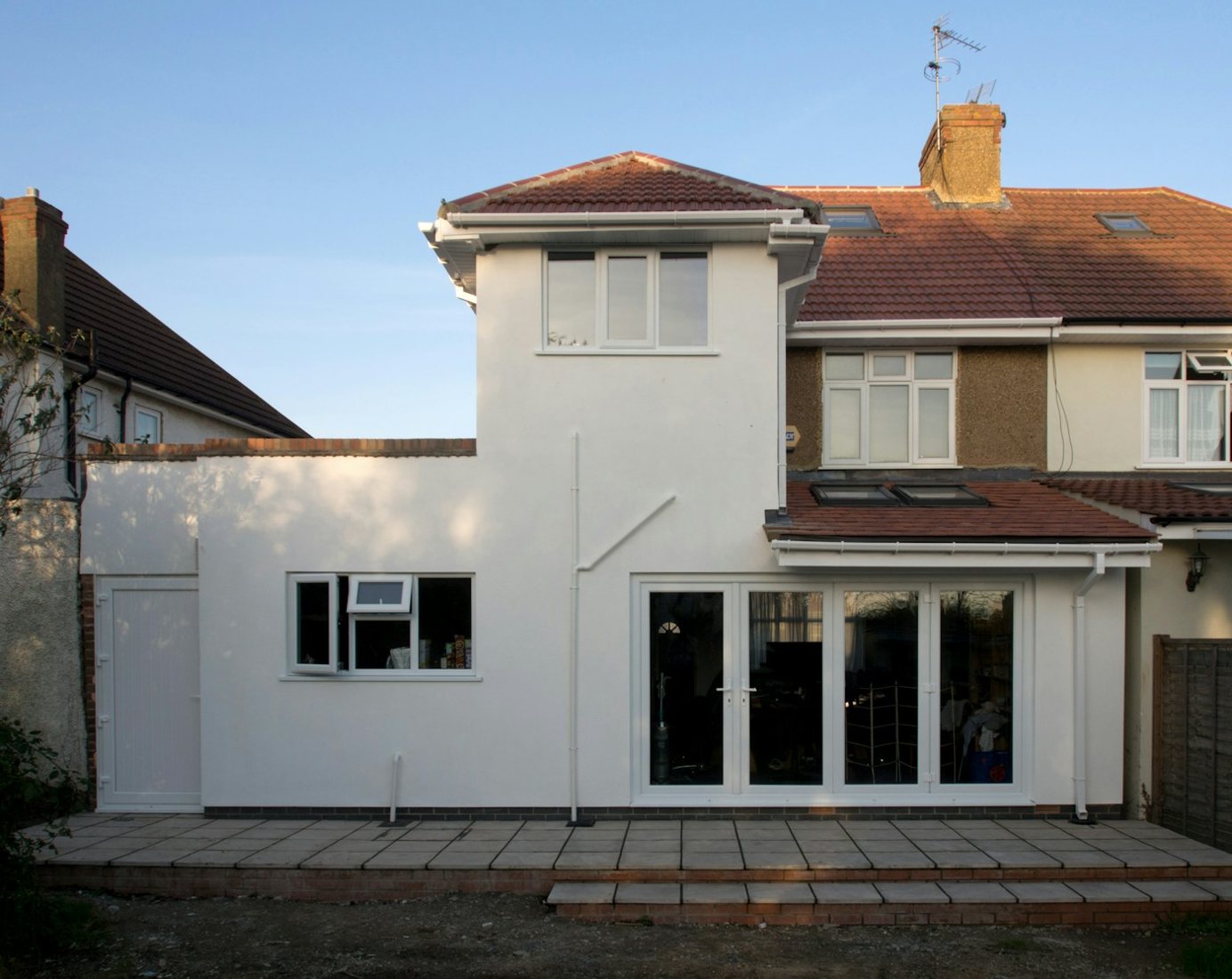 Completed rendered rear house extension with French doors and tiled roof