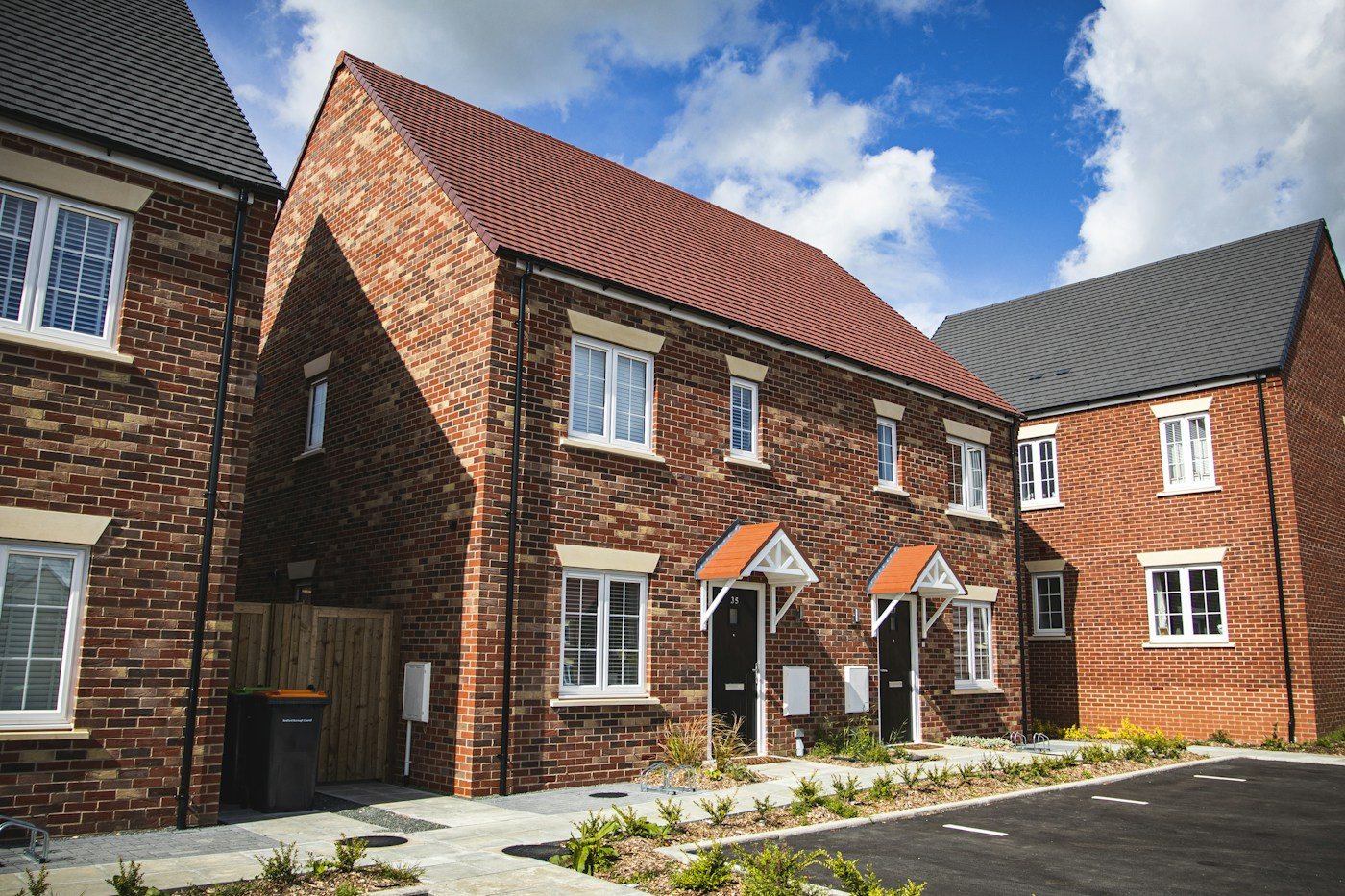 New red-brick homes with tiled roofs, front entrances and landscaped paths