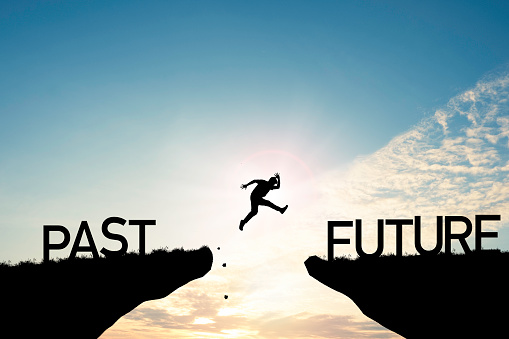 A person jumping across a gap toward future success