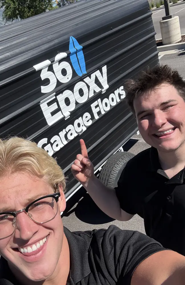 The two owners of 360Epoxy smiling in front of the 360 Epoxy Garage Floors trailer