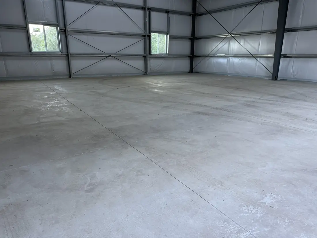 Shop before: bare concrete slab in a steel building
