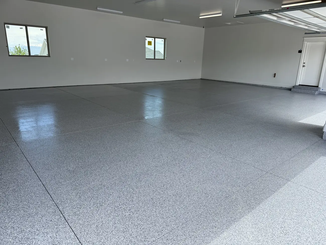 Large three-car garage with a new gray flake floor