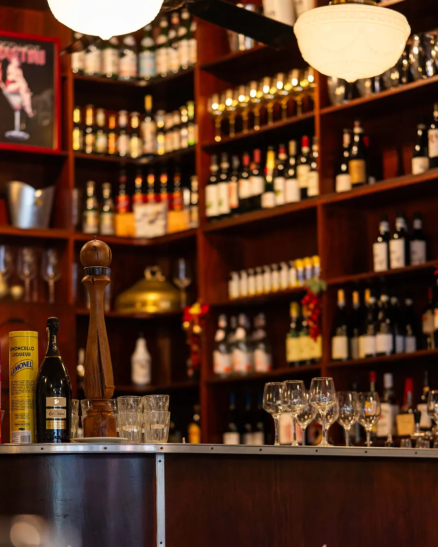 Grappino's bar: a timber wall of Italian wines and spirits under retro pendant lights